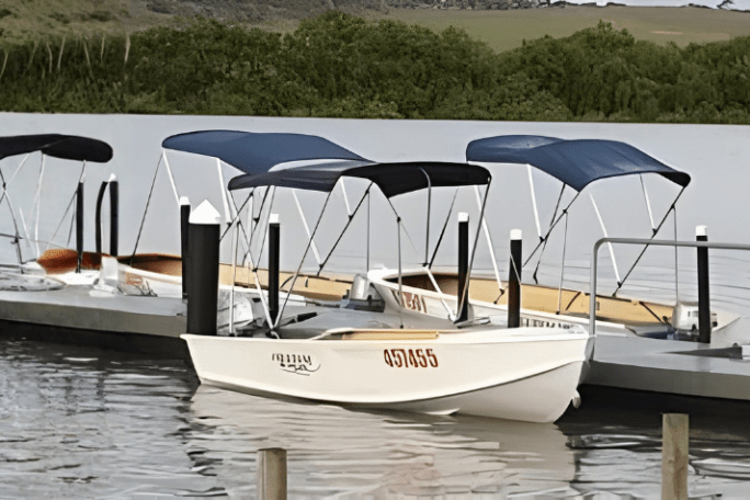 Several small boats docked at a pier on a calm lake.