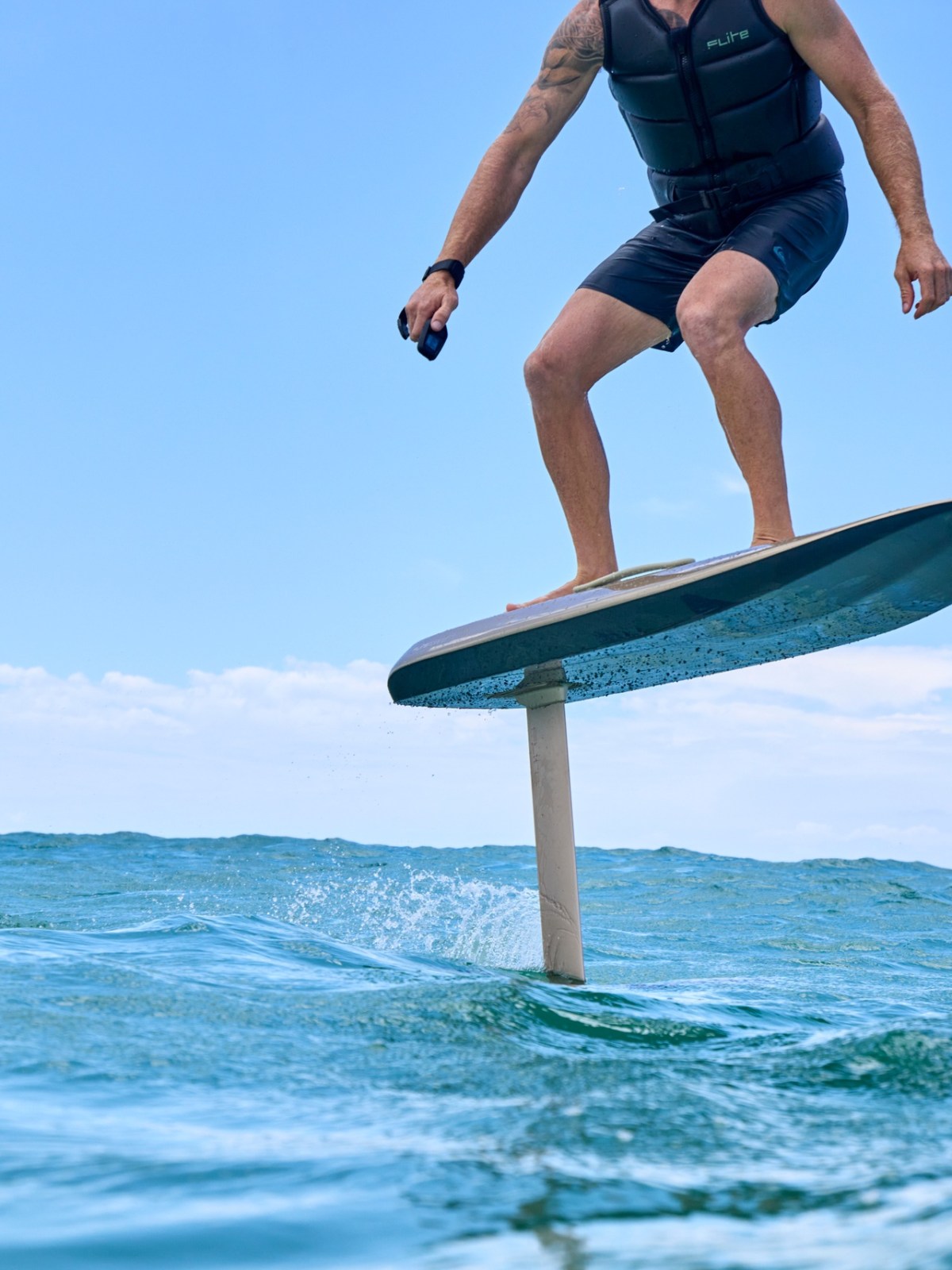 Person riding a hydrofoil surfboard over ocean waves.