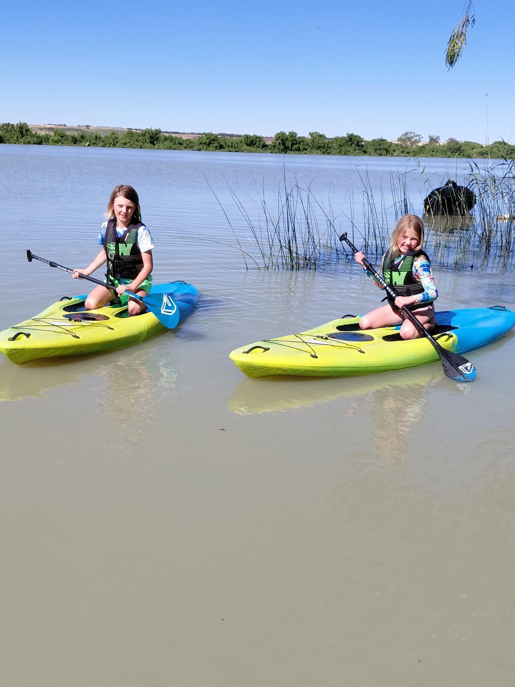 Two people kayaking on a calm body of water.